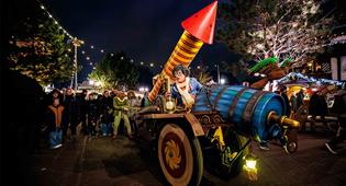 Efteling characters Max and Moritz sit on a colorful cart with a large firework rocket.