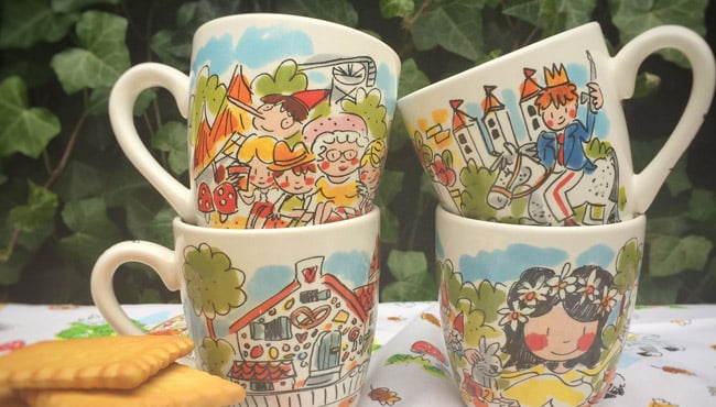 Mokken van Efteling Blond Amsterdam tentoongesteld op een tuintafel.